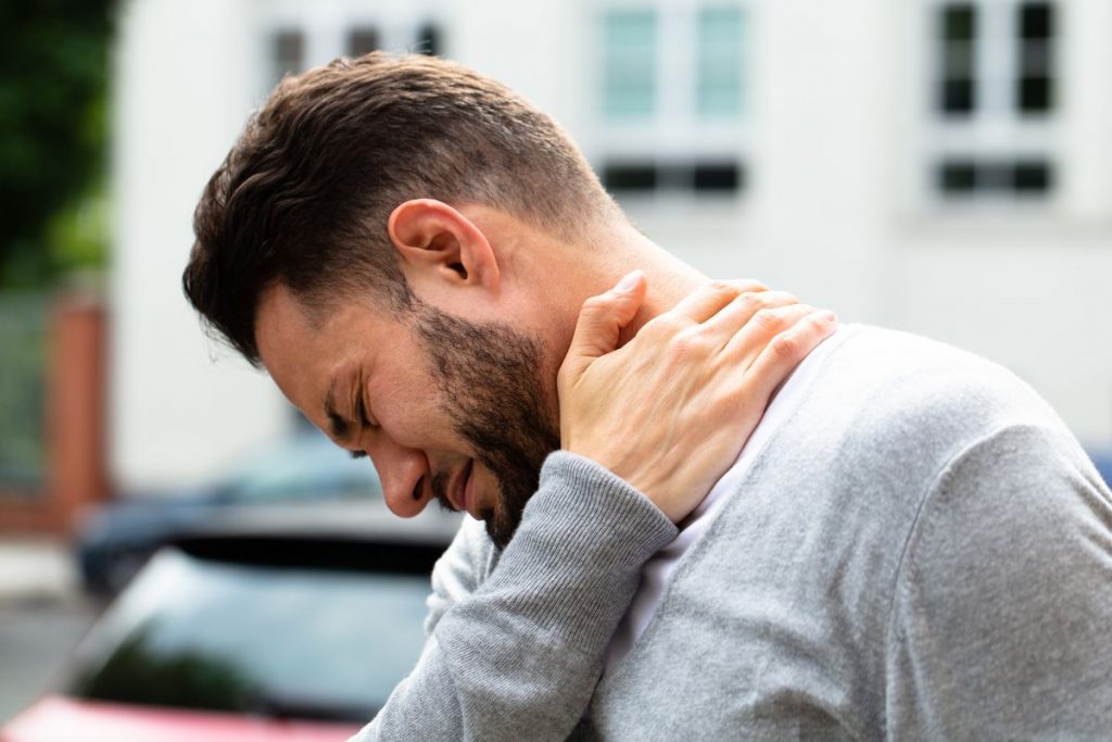 Hombre realizando estiramientos para aliviar la cervicalgia.